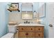 Blue bathroom with wood vanity, modern fixtures, and decorative shelf at 6913 8Th W Ave, Bradenton, FL 34209