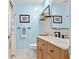 Bright blue bathroom with wood vanity and updated fixtures and shelves at 6913 8Th W Ave, Bradenton, FL 34209
