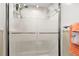Close up of the bathroom shower with glass doors, white tiles, and modern fixtures at 6913 8Th W Ave, Bradenton, FL 34209