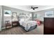 Cozy bedroom with a ceiling fan, two windows and gray wood flooring at 6913 8Th W Ave, Bradenton, FL 34209