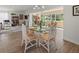Open dining area featuring a glass table and chairs with views to the seating area and front yard at 6913 8Th W Ave, Bradenton, FL 34209