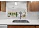 A close-up shot of a modern kitchen sink with a bright view to the living area at 6913 8Th W Ave, Bradenton, FL 34209
