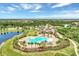 An aerial view showcasing the community pool, clubhouse, and lush landscaping at 7130 Whittlebury Trl, Bradenton, FL 34202