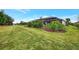 Spacious backyard offers lush green grass, landscaping, and a screened lanai at 7130 Whittlebury Trl, Bradenton, FL 34202