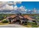 An exterior aerial view of the clubhouse with stunning architecture and a beautifully landscaped entrance at 7130 Whittlebury Trl, Bradenton, FL 34202
