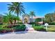 The entrance to the community clubhouse features lush landscaping and palm trees at 7130 Whittlebury Trl, Bradenton, FL 34202
