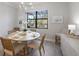 Bright dining area with modern lighting and a large window showcasing the outdoor scenery at 7130 Whittlebury Trl, Bradenton, FL 34202