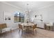 Cozy dining area with modern lighting and view of the backyard through a large window at 7130 Whittlebury Trl, Bradenton, FL 34202