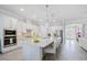 Bright kitchen showcasing a spacious island with seating, stainless steel appliances, and seamless flow to other rooms at 7130 Whittlebury Trl, Bradenton, FL 34202