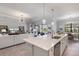 Open-concept kitchen with an island and stainless steel appliances flows into a living room and dining area at 7130 Whittlebury Trl, Bradenton, FL 34202
