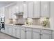 Detailed view of the kitchen cabinets featuring a stylish backsplash, and stainless steel range hood at 7130 Whittlebury Trl, Bradenton, FL 34202