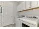 Well-equipped laundry room featuring modern washer and dryer, along with ample cabinet space at 7130 Whittlebury Trl, Bradenton, FL 34202