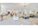Bright, open-concept living room with a modern chandelier, and a seamless flow into the kitchen and dining area at 7130 Whittlebury Trl, Bradenton, FL 34202