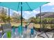 Charming outdoor dining area under an umbrella, surrounded by lush landscaping and a serene view, ideal for al fresco meals at 7130 Whittlebury Trl, Bradenton, FL 34202