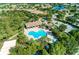 Aerial view of community pool and hot tub surrounded by lush landscaping and sidewalks at 7130 Whittlebury Trl, Bradenton, FL 34202