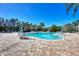 Community pool surrounded by a brick patio with tables, chairs and umbrellas at 7130 Whittlebury Trl, Bradenton, FL 34202