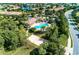 Aerial view of community pool with lounge area, volleyball court, surrounded by lush landscaping at 7130 Whittlebury Trl, Bradenton, FL 34202