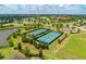 Aerial view of the tennis courts, the lake, and the surrounding residential community at 7130 Whittlebury Trl, Bradenton, FL 34202