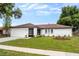 Newly renovated home with a white brick exterior, brown roof, and a well-manicured lawn at 722 Sailfish Dr, Brandon, FL 33511