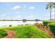 Community lake view surrounded by green grass, shrubs, and palm tree at 7911 Grand Estuary Trl # 102, Bradenton, FL 34212