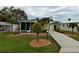 The home has an appealing exterior with mature landscaping and a well-manicured lawn at 8411 Regal Way, Palmetto, FL 34221