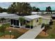 Charming yellow home with a manicured lawn, mature trees and landscaping at 8411 Regal Way, Palmetto, FL 34221