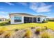 Home's backyard features a screened patio and lush landscaping at 8921 Artisan Way, Sarasota, FL 34240