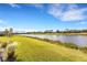 Scenic backyard view with pond, grass and palm trees at 8921 Artisan Way, Sarasota, FL 34240