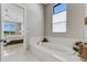 Relaxing bathroom with a freestanding tub and view into bedroom at 8921 Artisan Way, Sarasota, FL 34240