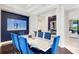 Modern dining room featuring a white table and blue chairs at 8921 Artisan Way, Sarasota, FL 34240