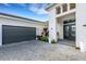 Two-car garage with dark gray doors and paved driveway at 8921 Artisan Way, Sarasota, FL 34240