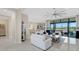 Open living space with white sofas, kitchen, and access to patio at 8921 Artisan Way, Sarasota, FL 34240