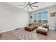 Bright living room featuring a sectional sofa, large windows, and a ceiling fan at 8921 Artisan Way, Sarasota, FL 34240