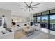 Open living area with white sofas, kitchen, and sliding glass doors at 8921 Artisan Way, Sarasota, FL 34240