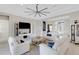 Spacious living room with white sofas, large TV, and view of backyard at 8921 Artisan Way, Sarasota, FL 34240