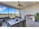 Covered patio with outdoor kitchen, seating area, and water view at 8921 Artisan Way, Sarasota, FL 34240