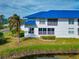 Back view of a two-story home with a balcony, blue roof, and green lawn at 901 Sandpiper Cir # 901, Bradenton, FL 34209