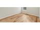 Empty bedroom corner with wood-look flooring, window, and white baseboards at 9827 Edmonton Dr, Land O Lakes, FL 34638