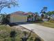 Concrete driveway leading to an attached two-car garage and a yellow two-story home at 779 Nectar Rd, Venice, FL 34293