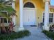 Welcoming front porch area with white double doors, columns, and tropical landscaping at 779 Nectar Rd, Venice, FL 34293