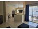Living room with tile flooring, a partial wall separating the kitchen and dining areas, and glass doors to the pool at 779 Nectar Rd, Venice, FL 34293