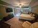Spacious main bedroom with king-size bed, ceiling fan, and a sitting area at 779 Nectar Rd, Venice, FL 34293