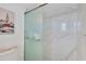 Modern shower with marble-tiled walls and glass door at 101 S Gulfstream Ave # 15E, Sarasota, FL 34236