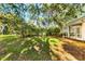 Lush backyard with mature trees and a screened patio at 108 Corte Del Rosa, Venice, FL 34285