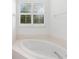 Relaxing bathroom with corner bathtub and window at 108 Corte Del Rosa, Venice, FL 34285