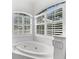 Oval bathtub and large windows with plantation shutters at 108 Corte Del Rosa, Venice, FL 34285