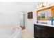 Elegant bathroom with dark vanity, marble top, and bathtub at 108 Corte Del Rosa, Venice, FL 34285