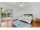 Bright bedroom with a queen bed, wood floors and sliding doors to backyard at 108 Corte Del Rosa, Venice, FL 34285