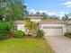 House exterior featuring a two-car garage and manicured lawn at 108 Corte Del Rosa, Venice, FL 34285