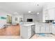 Open kitchen with white cabinets, island, and stainless steel appliances at 108 Corte Del Rosa, Venice, FL 34285